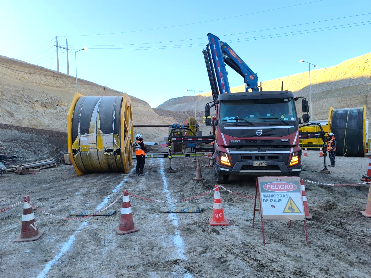 Camión grúa y rollos de cinta preparados para el cambio de una correa transportadora en faena.