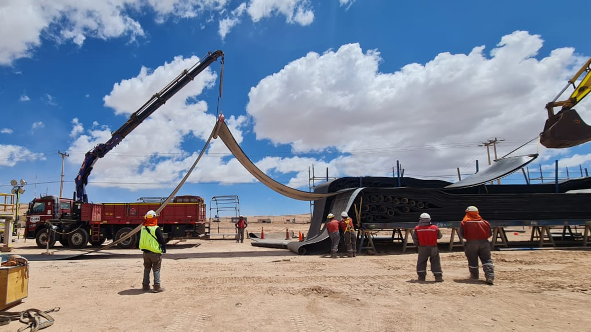 Grúa eleva una sección de cinta transportadora plegada durante los preparativos de montaje en faena.