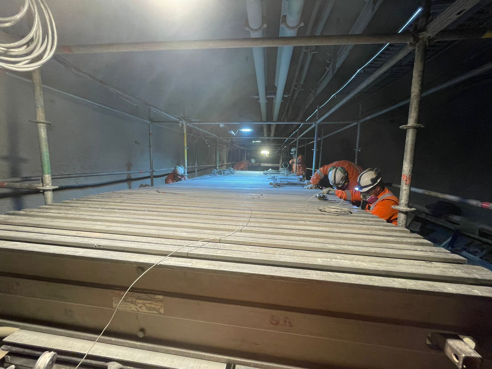 Equipo de trabajo interviene una cinta transportadora en una faena subterránea.